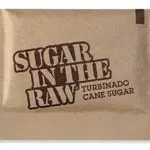 A brown paper packet labeled "Sugar In The Raw Turbinado Cane Sugar" in bold, dark lettering, often found in cafés near early learning centres or preschool schools near me.