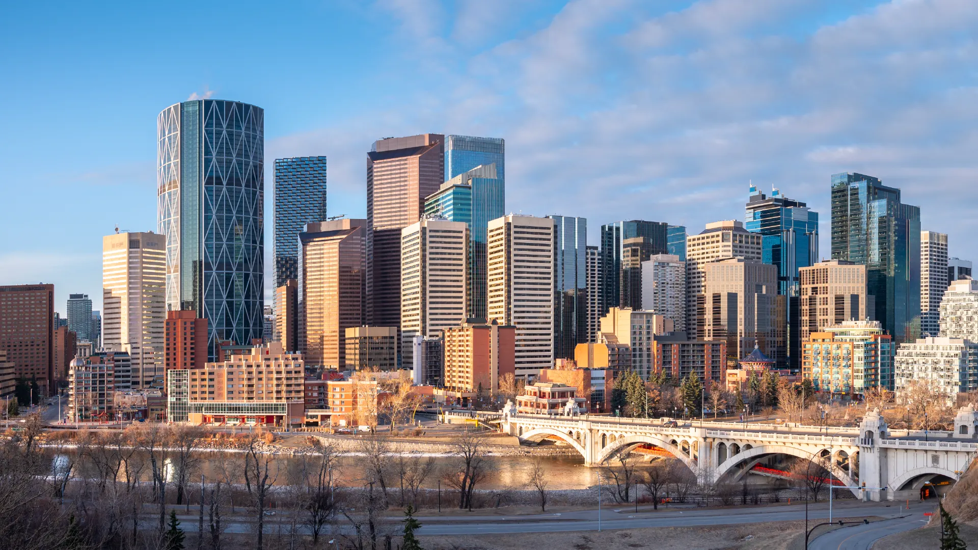 Panoramic view of a modern city skyline with tall glass skyscrapers, a river, and a white arched bridge in the foreground—ideal for families seeking preschools close to me or exploring early learning centres nearby.