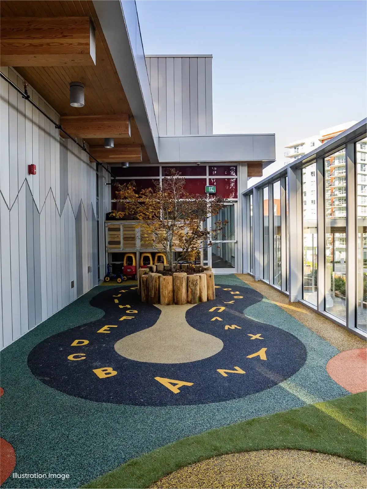 Outdoor play area at our early childhood care program features colorful, alphabet-themed flooring, tree stump seating, a central tree, and children's chairs—perfect for families seeking preschools close to me with modern spaces.
