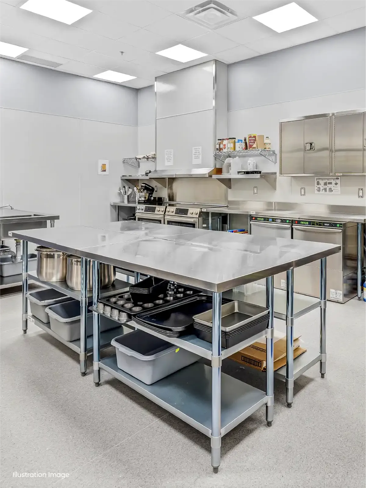 A commercial kitchen with stainless steel countertops, open shelving holding kitchen tools, bins, and baking trays—ideal for early learning centres or preschools close to me focusing on hands-on cooking activities. The brightly lit room features modern appliances and storage cabinets.