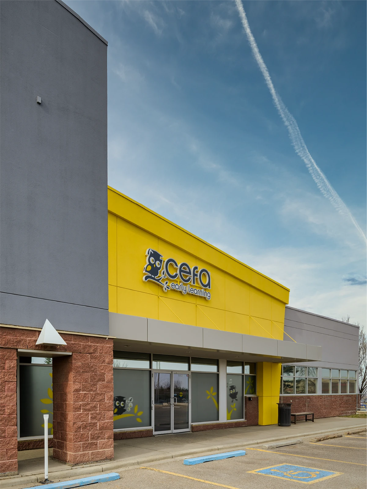 A modern building with gray and yellow exterior walls features a "cefa early learning" sign above the entrance. As one of the top early learning centres, it offers convenient parking and easy access for families searching for preschools close to me.