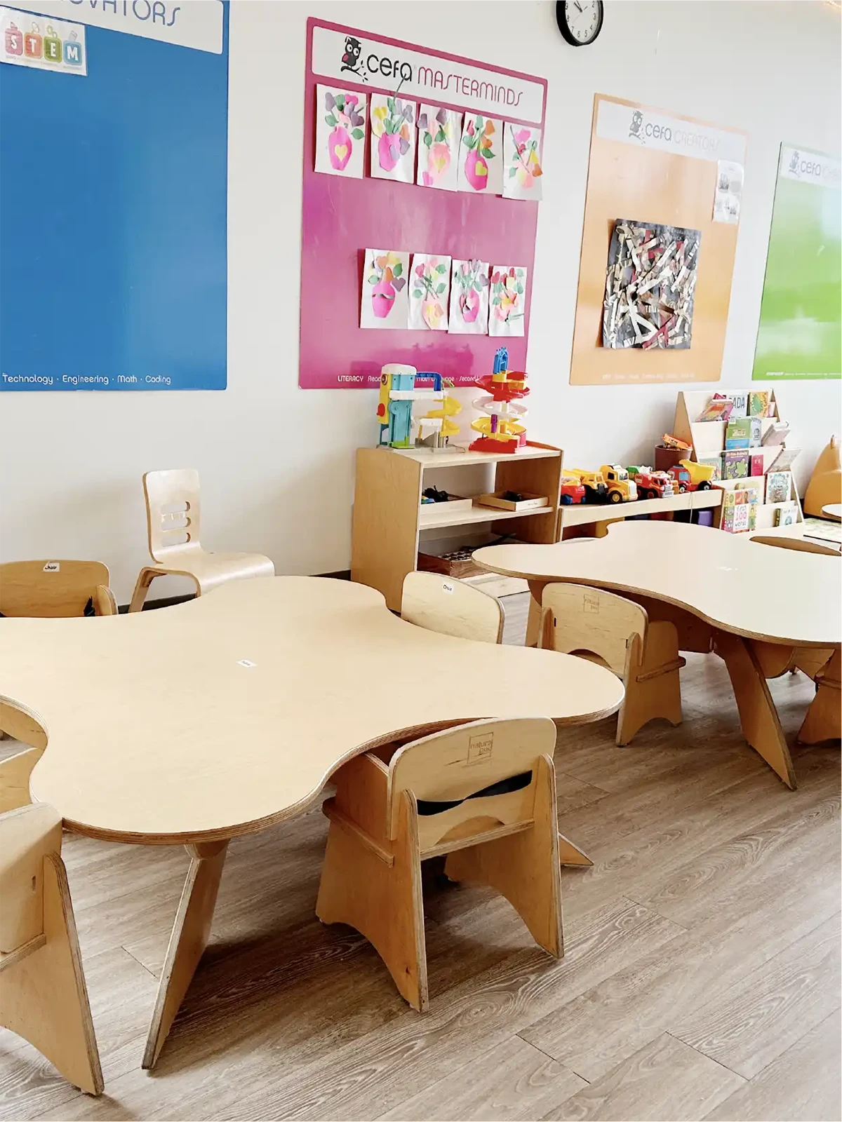 A bright classroom at one of the best early learning centres, featuring wooden tables and chairs, educational toys, and colorful posters with children's artwork. The clean, organized space creates a welcoming atmosphere for young learners.